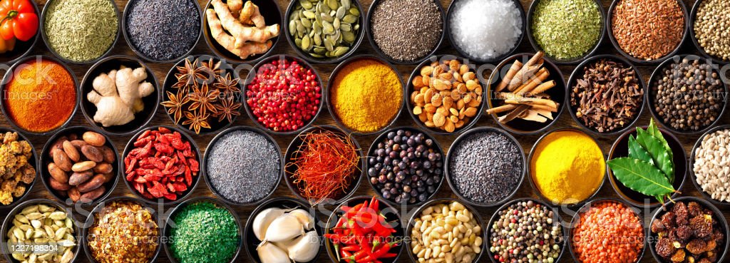 Colourful background from various herbs and spices for cooking in bowls. Top view